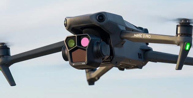 Close up image of a DJI Mavic 3 Pro in flight in a sandy terrain